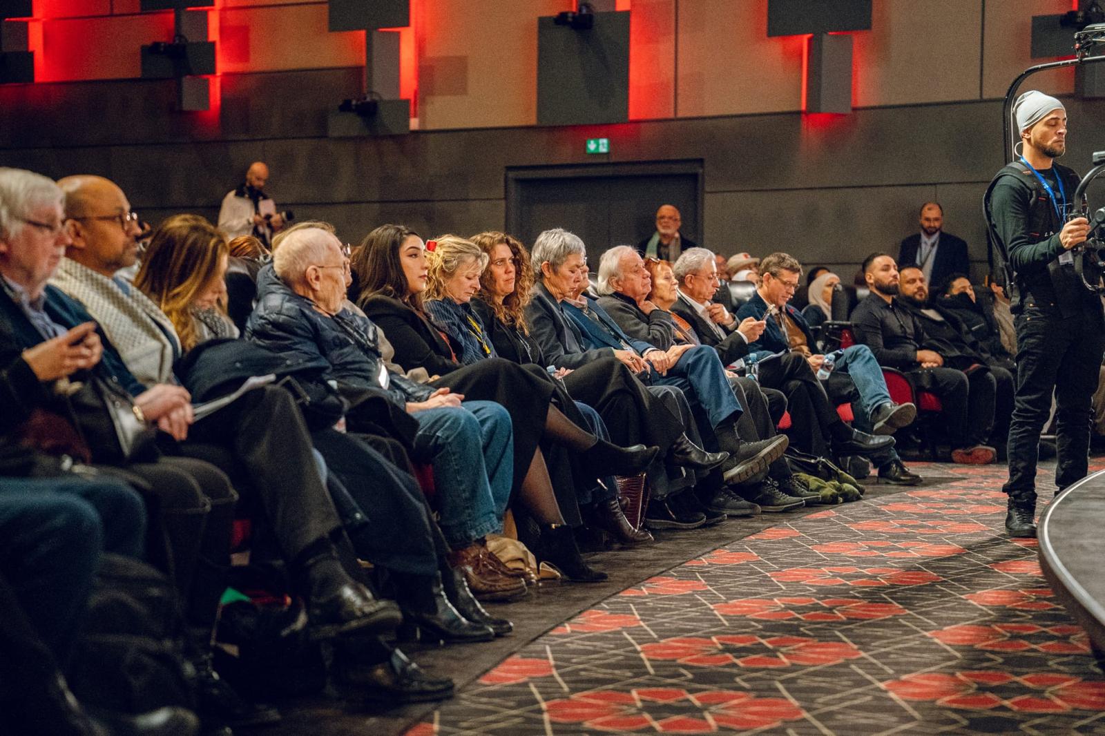 Front rows of seated participants in the conference hall.