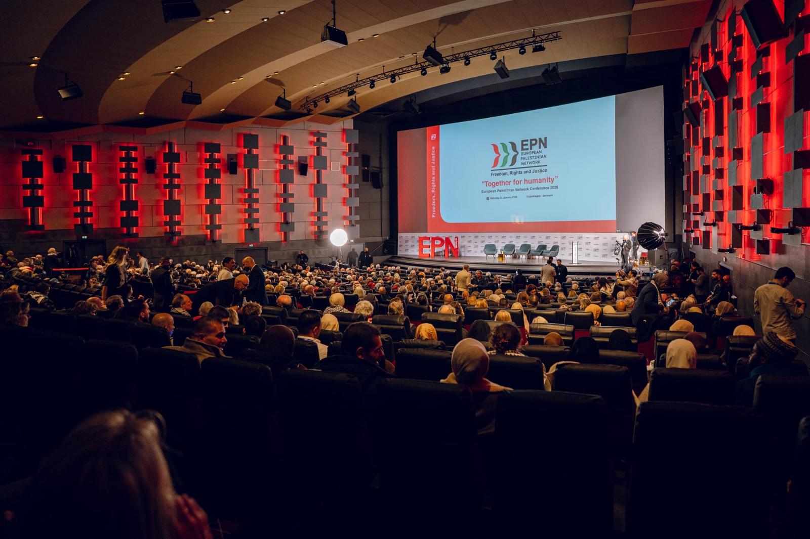 Wide view of the hall from the back, with the large stage screen showing EPN branding.