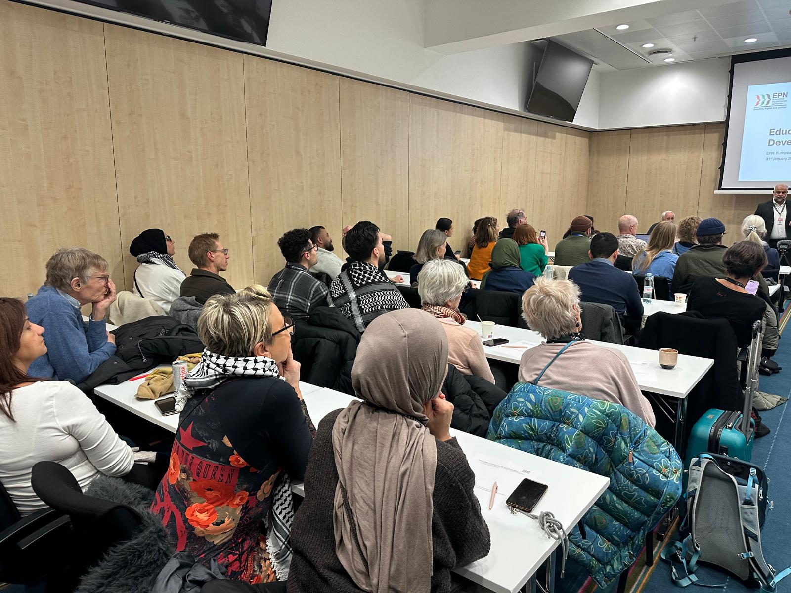 Workshop room with participants gathered around the tables.